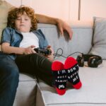 Rectangular red and black gamer throw pillow cover with a pair of red and white anti-skid gaming socks.