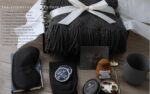 A grey and navy CASTATEO comfort care package featuring a knitted throw blanket, ceramic mug, and a small 'Positive Potato' t