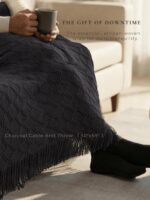 A grey and navy CASTATEO comfort care package featuring a knitted throw blanket, ceramic mug, and a small 'Positive Potato' t