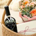 Heart-shaped glass ornament featuring "The Year We Became Mr & Mrs - 2026" in a navy blue gift box with an ivory ribbon.