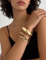 Three iF YOU chunky 14k gold plated bangle bracelets stacked on a woman's wrist, showing a radiant finish.