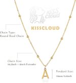 Close-up of a delicate 14K gold-plated initial 'W' necklace on a simple bead chain, worn by a woman.