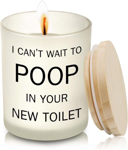 Frosted white jar candle with humorous text "I CAN'T WAIT TO POOP IN YOUR NEW TOILET" and a lit wick, on a neutral background
