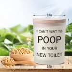 Frosted white jar candle with humorous text "I CAN'T WAIT TO POOP IN YOUR NEW TOILET" and a lit wick, on a neutral background