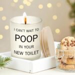 Frosted white jar candle with humorous text "I CAN'T WAIT TO POOP IN YOUR NEW TOILET" and a lit wick, on a neutral background