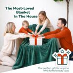 Adult wearing a Super Blanky Forest Green wearable blanket, lounging comfortably on a couch, showcasing its plush fabric and